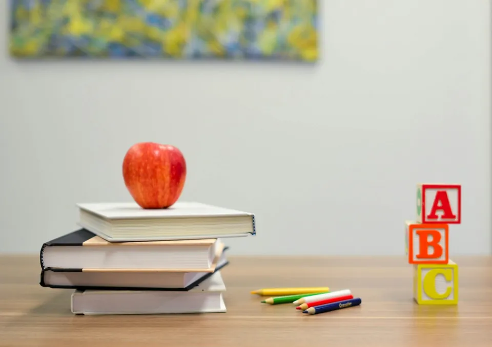 Livros, lápis e blocos com letras sobre uma mesa